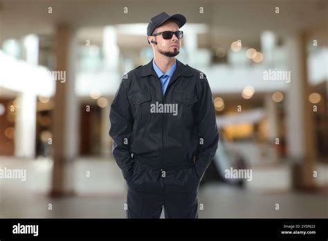 Serious Security Guard With Earpiece In Shopping Mall Stock Photo Alamy