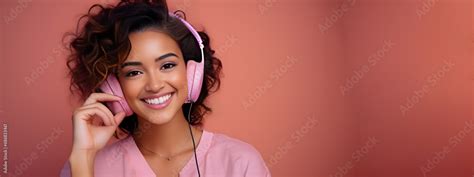 Adolecente Latina Con Fondo Rosa Audifonos Escuchando Musica Sonriente Y Relajada Stock Photo