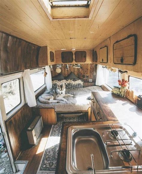 The Interior Of An Rv With Wood Paneling And Stainless Steel Sink