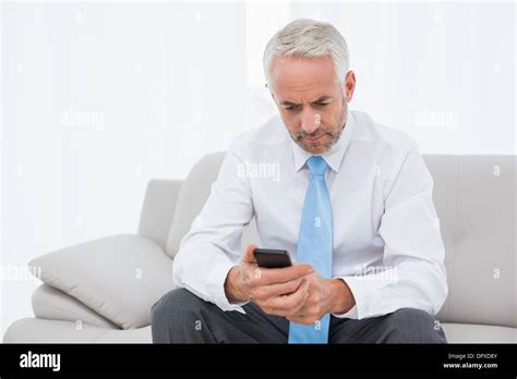 Elegant Mature Businessman Text Messaging At Home Stock Photo Alamy