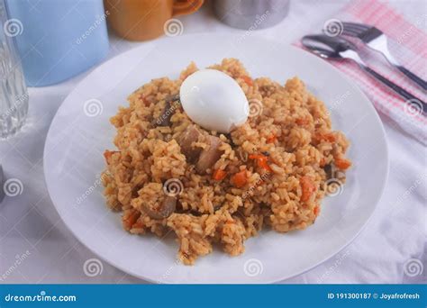 Yummy Nigerian Jollof Rice Served With A Boiled Egg And Chopped Meat
