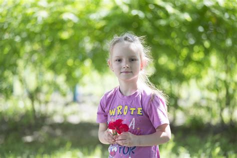 Beautiful Six Year Old Girl In Summer With A Flower Portrait Of A