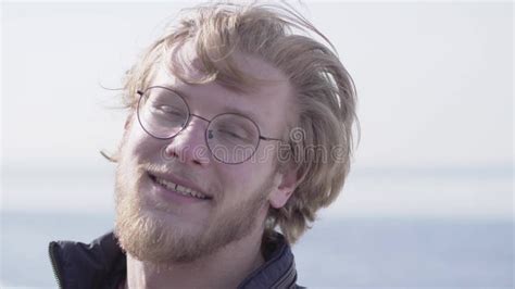 Portrait Of Funny Bearded Man In Glasses Shaking His Blond Hair