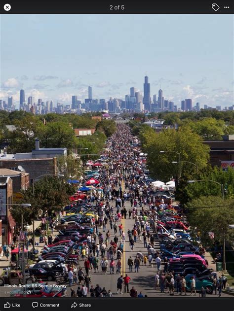 A Large Crowd Of People Walking Down A Street Next To Tall Buildings In