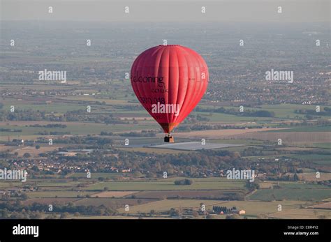 Aerial View Of Red Hot Air Balloon Flying Over Staffordshire Countryside North Of Lichfield