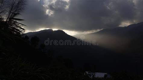 Bright Sunlight Shining Through Hole Of Clouds To Dark Scene Of