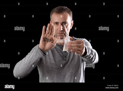 Mature Junkie With Drugs And Word Stop On His Palm Against Black