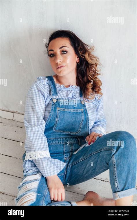 Portrait Of A Beautiful Blonde Woman In A Denim Jumpsuit Stock Photo Alamy