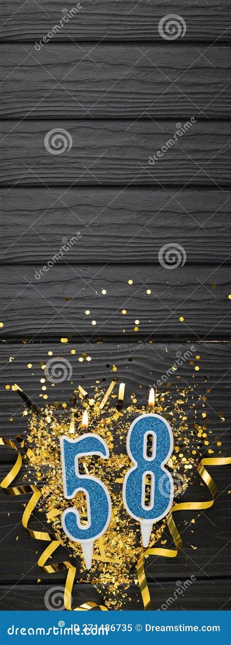 Number 58 Blue Celebration Candle And Gold Confetti On Dark Wooden