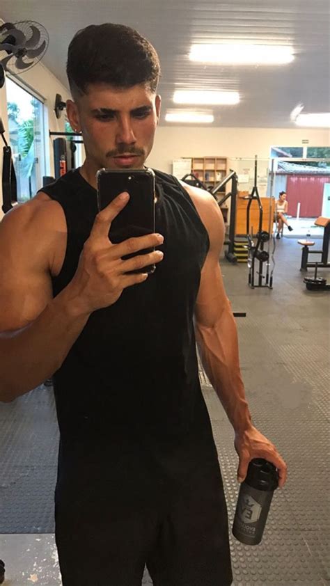 A Man Taking A Selfie In The Gym With His Cell Phone And Water Bottle