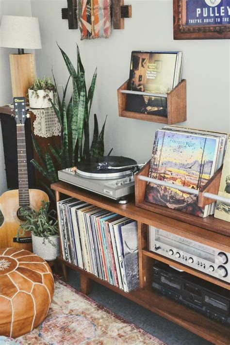 A Record Player Sitting On Top Of A Wooden Shelf Next To A Plant And