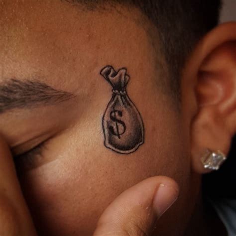 Money Bag Tattoo Behind Ear Inverted Cone Fire Pattern