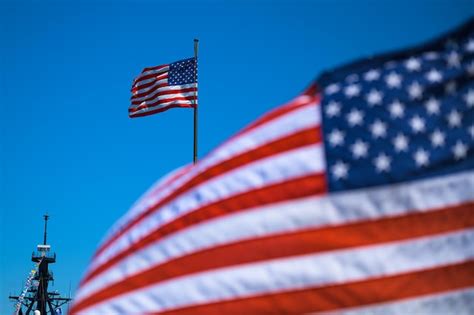 Premium Photo Low Angle View Of Flags Waving Against Clear Blue Sky