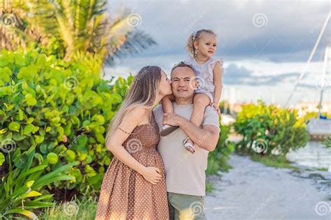 A Happy Mature Couple Over 40 With Their Two Daughters Enjoying A Leisurely Walk In A Park