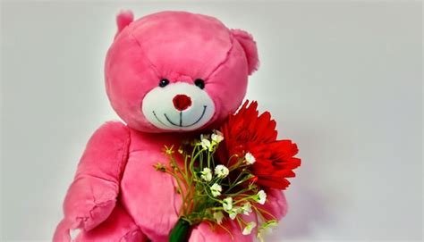 Premium AI Image | A pink teddy bear holds a bouquet of flowers.