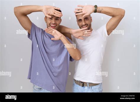 Homosexual Gay Couple Standing Over White Background Smiling Cheerful Playing Peek A Boo With