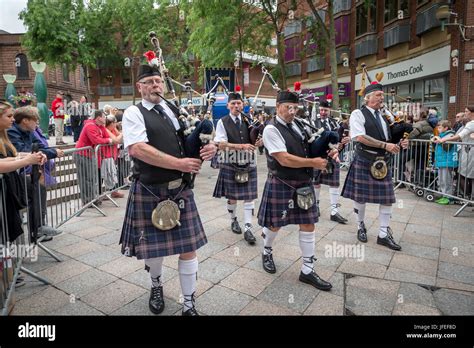 Pipers In The Oldham Scottish Pipe Band Marching Through The Town