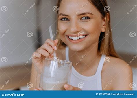 Happy Woman Sipping Milkshake In Kitchen Portrait Of A Happy Young