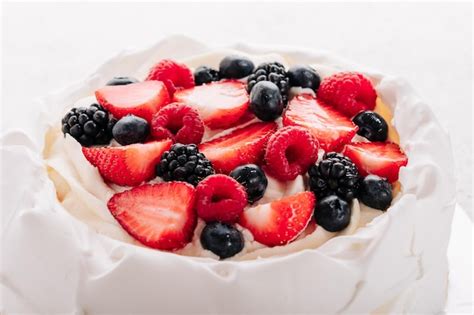 Tarta De Merengue Pavlova Con Bayas Frescas Sobre Fondo Blanco Foto