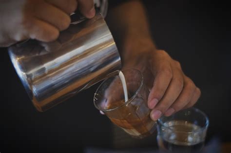 Premium Photo Midsection Of Person Pouring Milk In Coffee