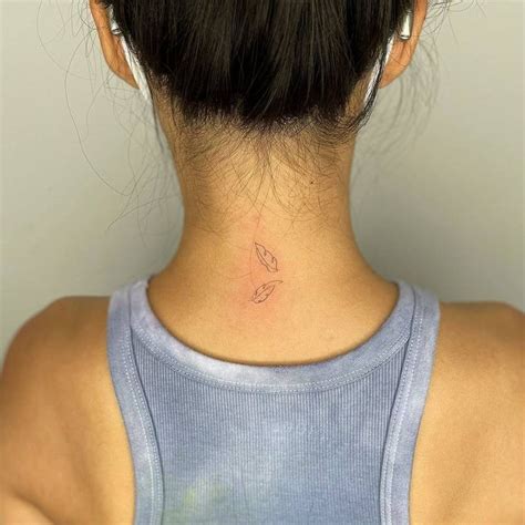 A Woman With A Small Tattoo On Her Neck