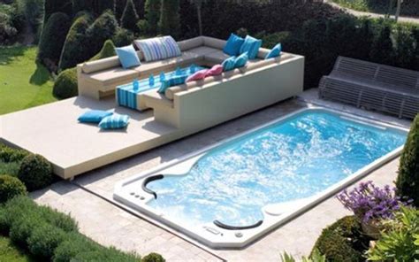 An Outdoor Swimming Pool With Lounge Chairs And Pillows On The Side