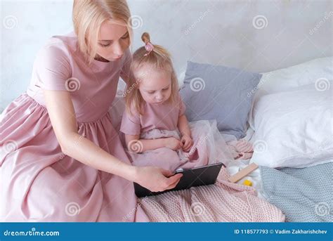 Mutter Und Tochterblick In Der Tablette Junge Attraktive Blonde Frau Mit Ihrer Kleinen Reizend