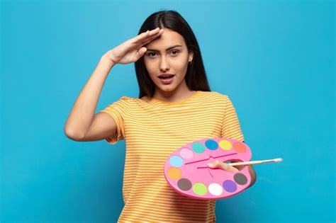 Mujer latina joven que parece feliz asombrada y sorprendida sonriendo y dándose cuenta de