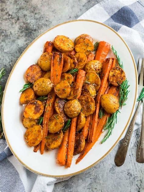 Perfect Roasted Potatoes And Carrots With Rosemary On A White Plate