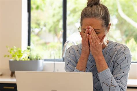 Stressed Mature Woman At Home Covering Face With Hands In Front Of
