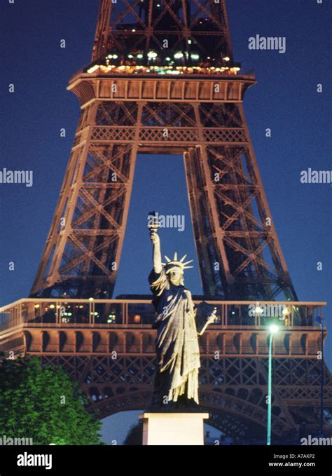 Statue Of Liberty And Eiffel Tower Above River Seine At Night In Paris