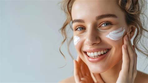 Premium Photo Young Attractive Woman Applies A Skin Care Cream On