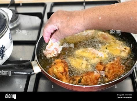 Elderly Woman Frying Chicken Wings In Hot Vegetable Palm Oil In Frying Pan Stock Photo Alamy