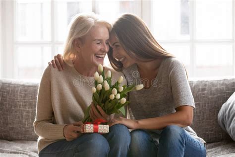 Äldre Vuxen Dotter Hälsar Mamma Med Blommor Arkivfoto Bild Av