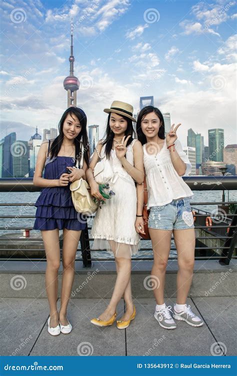 Portrait Of Happy Chinese Young Women Smiling With Modern Urban