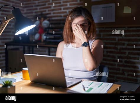 Brunette Woman Working At The Office At Night Tired Rubbing Nose And