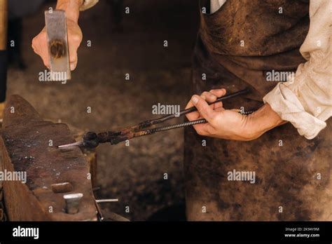 A Blacksmith Manually Forges Red Hot Metal On An Anvil With A Hammer Stock Photo Alamy