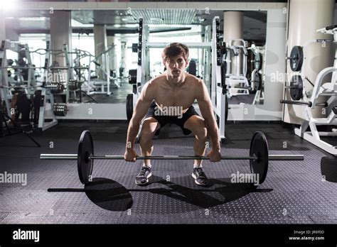 Confident Muscular Man Training Squats With Barbells Over Head Closeup