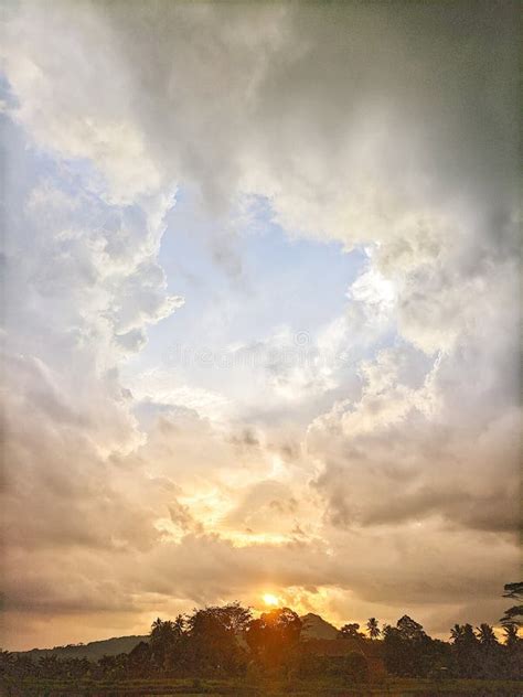 The View Of The Sunset Behind The Mountain With Beautiful Thick Clouds