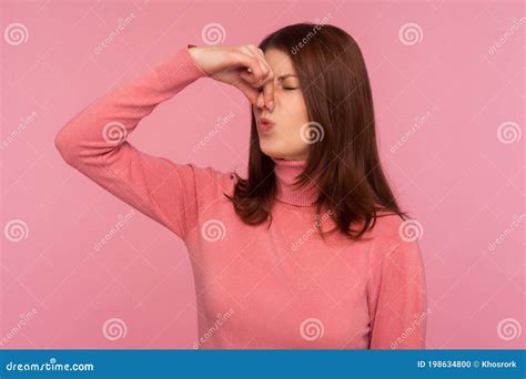 Unhappy Confused Brunette Woman Grabbing Nose With Fingers Feeling