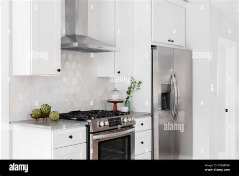 A Kitchen Detail With White Cabinets Stainless Steel Appliances Tan