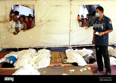 A Cambodian Military Policeman Checks The Bodies Of Stampede Victims