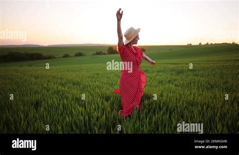 Young Woman Happily Walking In Slow Motion Through A Field Touching