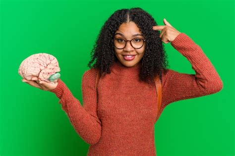 Joven Afroamericana Sosteniendo Un Modelo De Cerebro Aislado Foto Premium