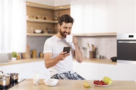 Glad Mature Caucasian Man With Beard In White T Shirt With Cup Drink
