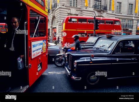 Motorcycle Couriers In Heavy Traffic With Black Cabs And Routemaster