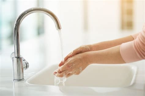 Premium Photo Keep Your Hands Clean Shot Of Hands Being Washed At A Tap