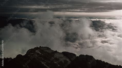 Una Persona En La Cima De Una Monta A Con Las Nubes Detr S Stock Photo