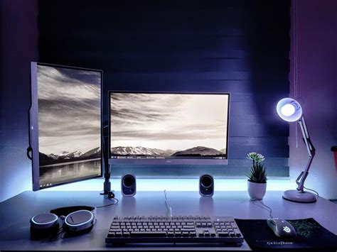 two computer monitors sitting on top of a desk in front of a keyboard ...