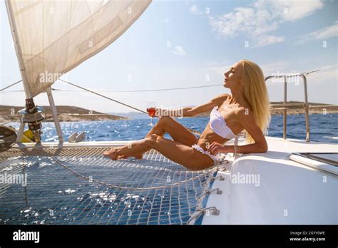Woman In Bikini Tanning And Relaxing Drinking Wine On A Summer
